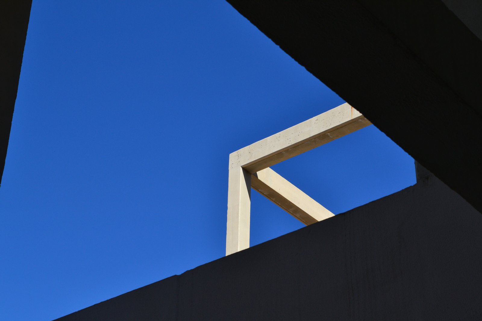 Concrete geometry against a hard blue sky